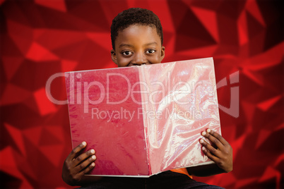 Composite image of cute boy reading book in library