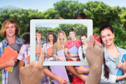 Composite image of hand holding tablet pc