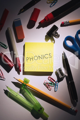 Phonics against students table with school supplies