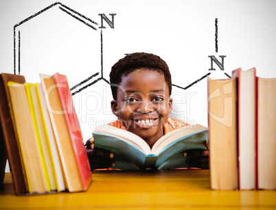 Composite image of cute boy reading book in library