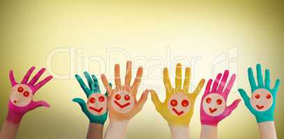 Composite image of hands with colourful smiley faces