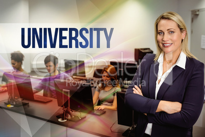 University against computer teacher smiling at camera with arms