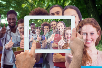 Composite image of hand holding tablet pc