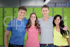 Composite image of four friends smiling and embracing each other