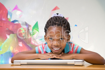 Composite image of smiling pupil sitting at her desk