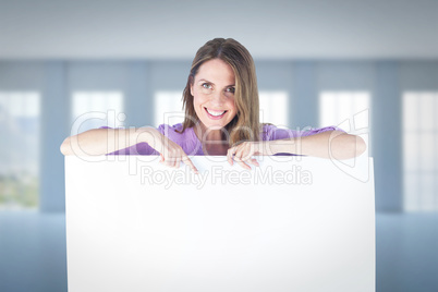 Composite image of portrait of smiling businesswoman pointing at