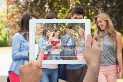 Composite image of hand holding tablet pc