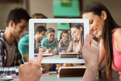 Composite image of hand holding tablet pc