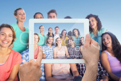 Composite image of hand holding tablet pc