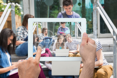 Composite image of hand holding tablet pc