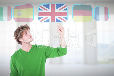 Composite image of handsome man smiling while pointing upward