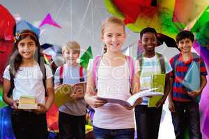 Composite image of smiling little school kids in school corridor