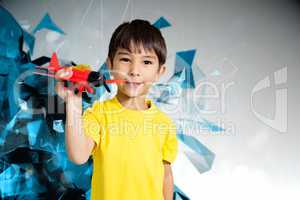 Composite image of cute boy playing with toy airplane