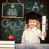 Composite image of smiling schoolgirl with graduation cap and ho