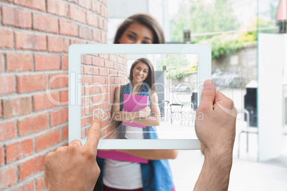 Composite image of hand holding tablet pc