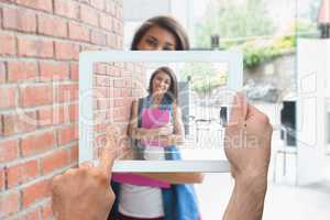 Composite image of hand holding tablet pc