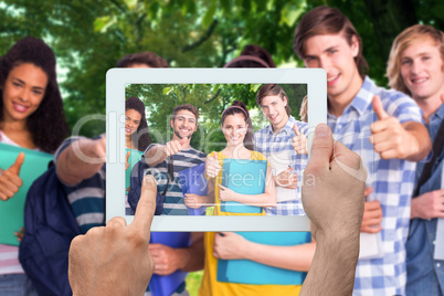 Composite image of hand holding tablet pc