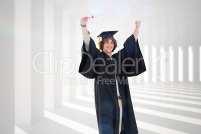 Composite image of male student in graduate robe raising his arm