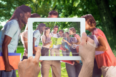 Composite image of hand holding tablet pc