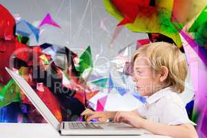 Composite image of cute boy using laptop