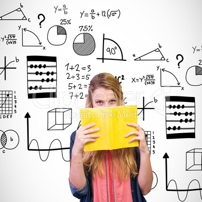 Composite image of student covering face with book in library