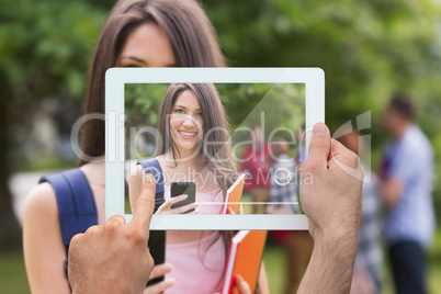 Composite image of hand holding tablet pc