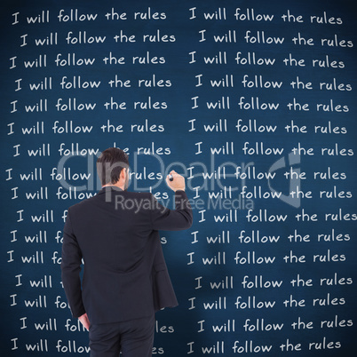 Composite image of businessman in suit writing with marker