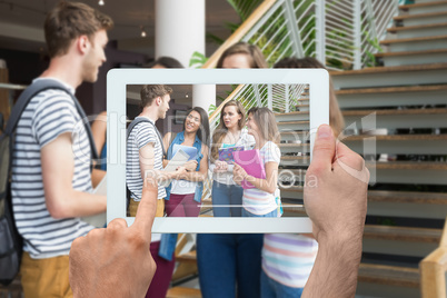 Composite image of hand holding tablet pc