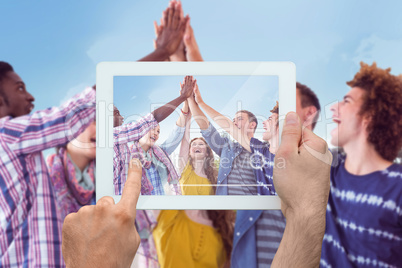 Composite image of hand holding tablet pc