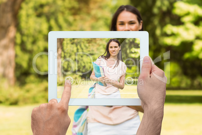 Composite image of hand holding tablet pc