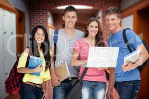 Composite image of a smiling group of students holding a laptop