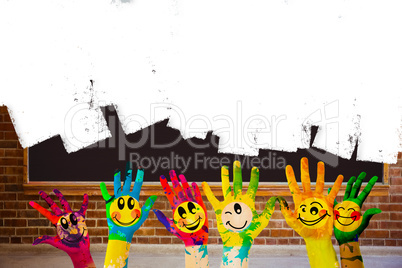 Composite image of hands with colourful smiley faces