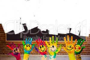 Composite image of hands with colourful smiley faces