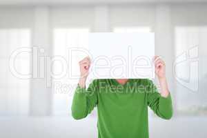 Composite image of man holding blank sign in front of face