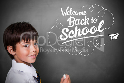 Composite image of cute pupil with chalkboard