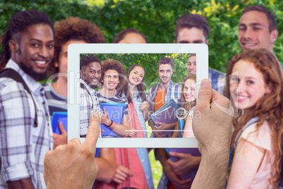 Composite image of hand holding tablet pc