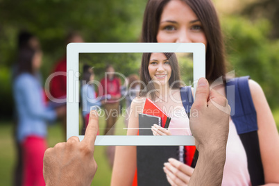 Composite image of hand holding tablet pc