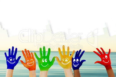 Composite image of hands with colourful smiley faces