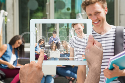 Composite image of hand holding tablet pc