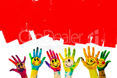 Composite image of hands with colourful smiley faces