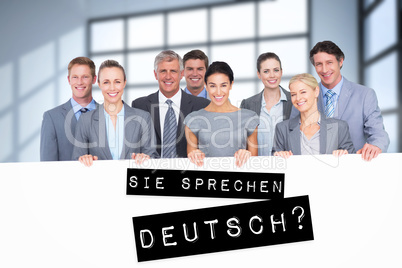 Composite image of smiling business team holding poster
