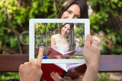 Composite image of hand holding tablet pc