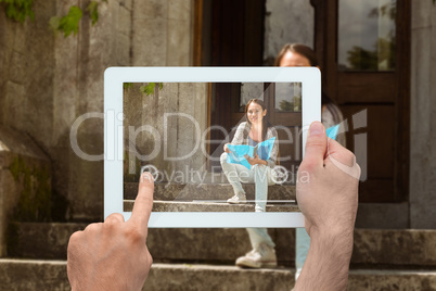 Composite image of hand holding tablet pc