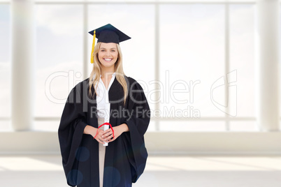 Composite image of smiling blonde student in graduate robe