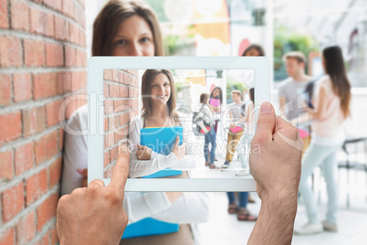 Composite image of hand holding tablet pc