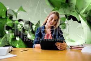 Composite image of student studying in the library with tablet