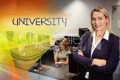 University against computer teacher smiling at camera with arms
