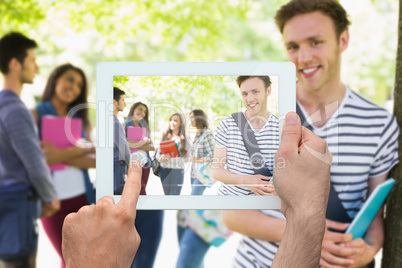 Composite image of hand holding tablet pc