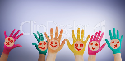 Composite image of hands with colourful smiley faces