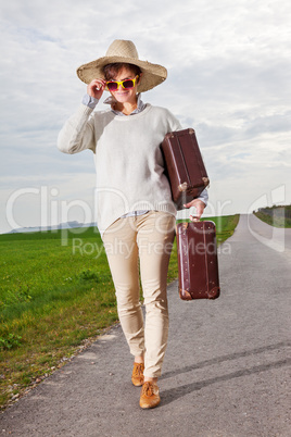 Woman running on the road and wearing holiday suitcase